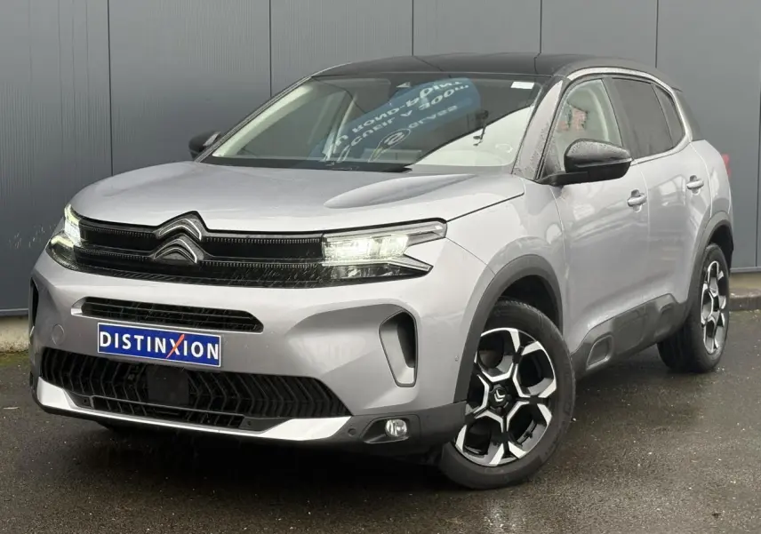 Vue 3/4 avant droite d'un Citroën C5 Aircross Hybrid gris Artense avec toit noir et jantes alliage 18 pouces.