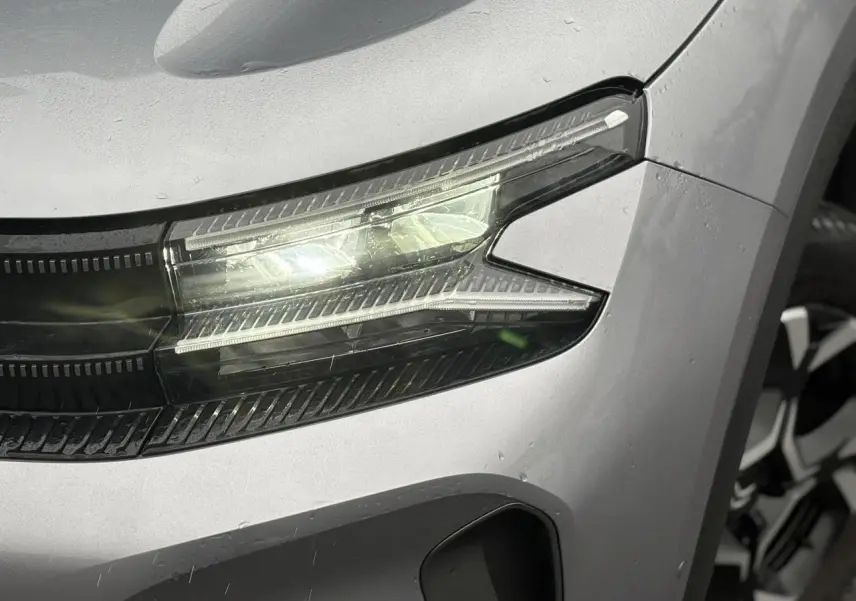 Gros plan sur le phare avant droit LED du Citroën C5 Aircross Hybrid gris Artense avec jante alliage visible.