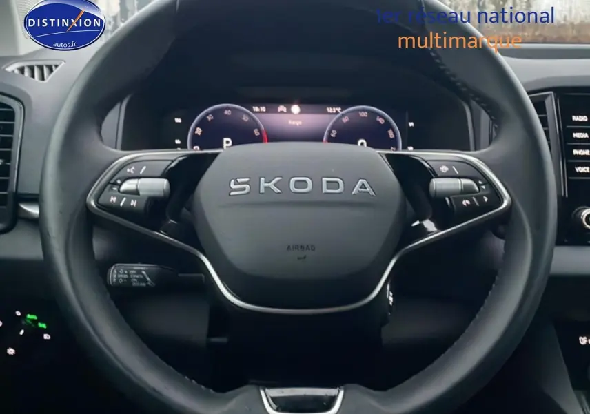 Vue rapprochée du volant cuir multifonction SKODA KAROQ 2025 avec tableau de bord numérique en arrière-plan.