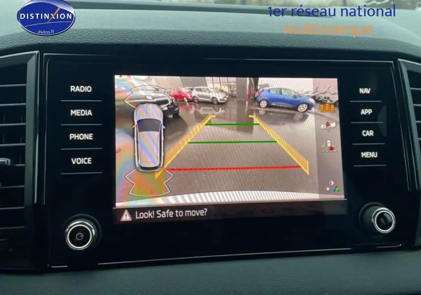 Écran tactile intérieur du Skoda Karoq blanc glacial montrant la caméra de recul avec aides au stationnement.