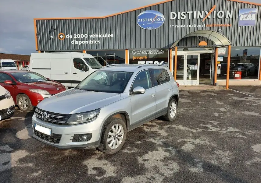 Volkswagen Tiguan gris argent 2012 en 3/4 avant droit sur parking devant concession Distinxion.