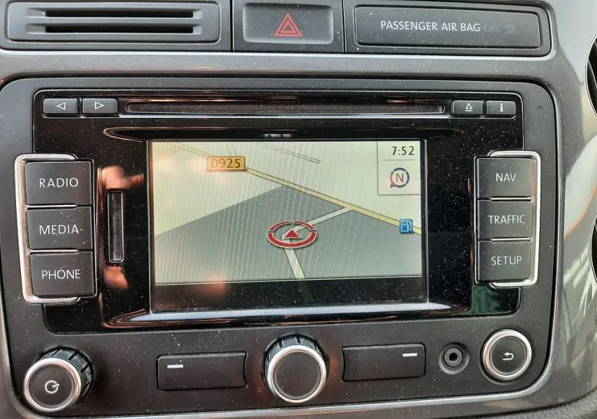 Vue rapprochée de l'écran de navigation du Volkswagen Tiguan 2.0 TDI 110 Sportline gris argent de 2012 avec commandes autour.