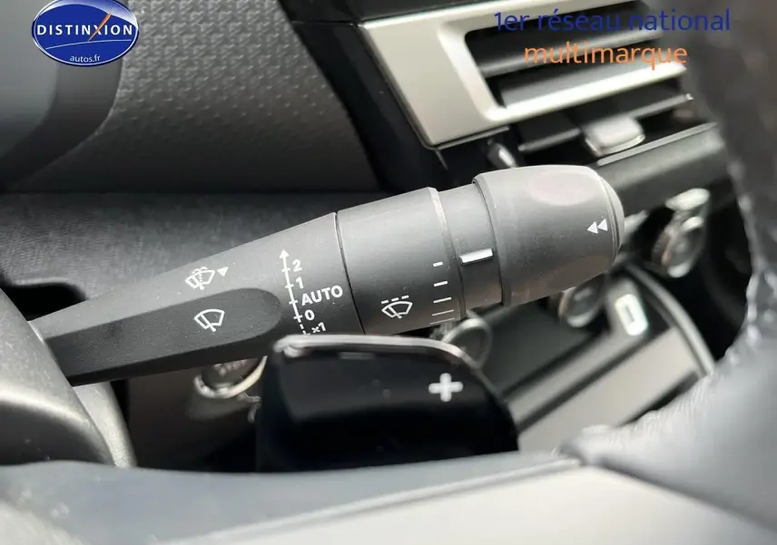 Gros plan sur la commande d'essuie-glace et palettes au volant d'une Citroën C4 noire métal 2025.