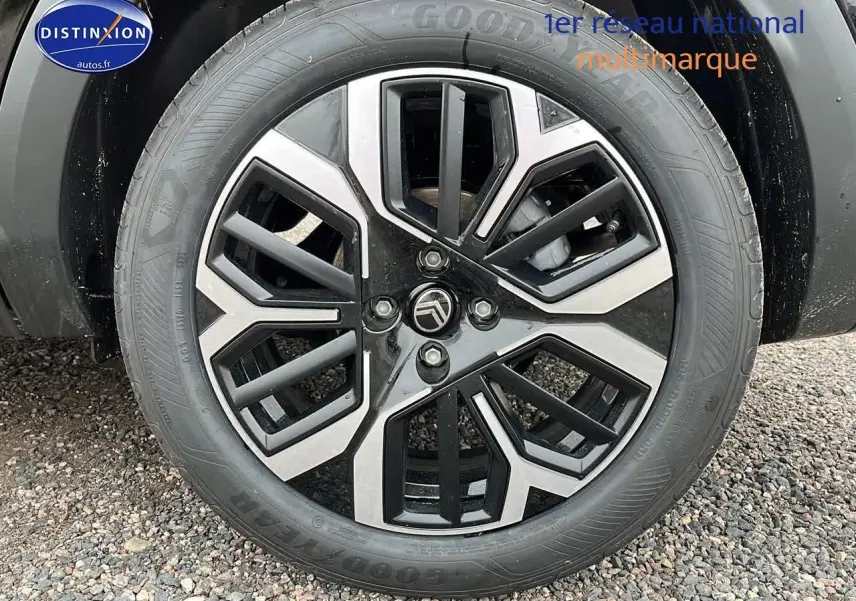 Vue arrière d'une Citroën C4 noire métal avec jantes alliage 18 pouces et rétroviseurs noirs brillants sur sol gravillonné.