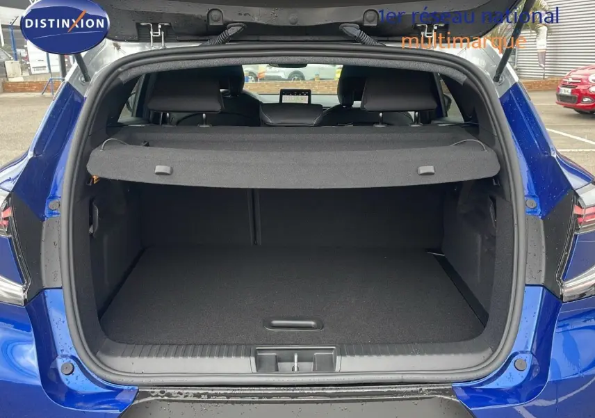 Coffre ouvert d'un Renault Captur E-Tech hybride 2025 bleu Iron Metal avec toit gris, vue arrière détaillée.