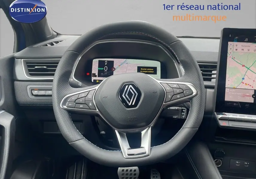 Vue intérieure centrée sur le volant du Renault Captur E-Tech hybride 2025 avec tableau de bord numérique et écran tactile.