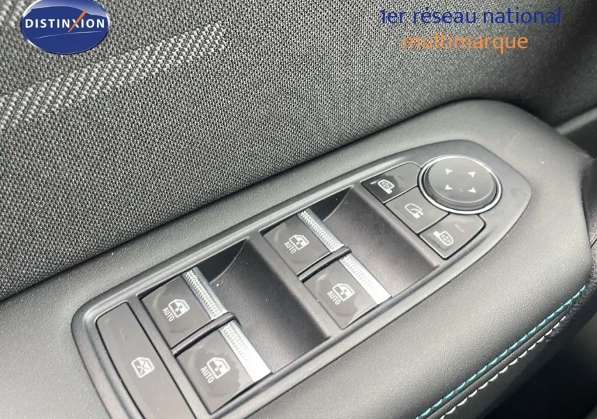 Gros plan sur les commandes des vitres électriques côté conducteur du Renault Captur bleu iron metal avec surpiqûres bleues.