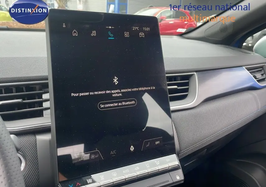 Vue intérieure du tableau de bord du Renault Captur E-Tech hybride 2025 avec écran tactile central vertical et garniture bleu iron metal.