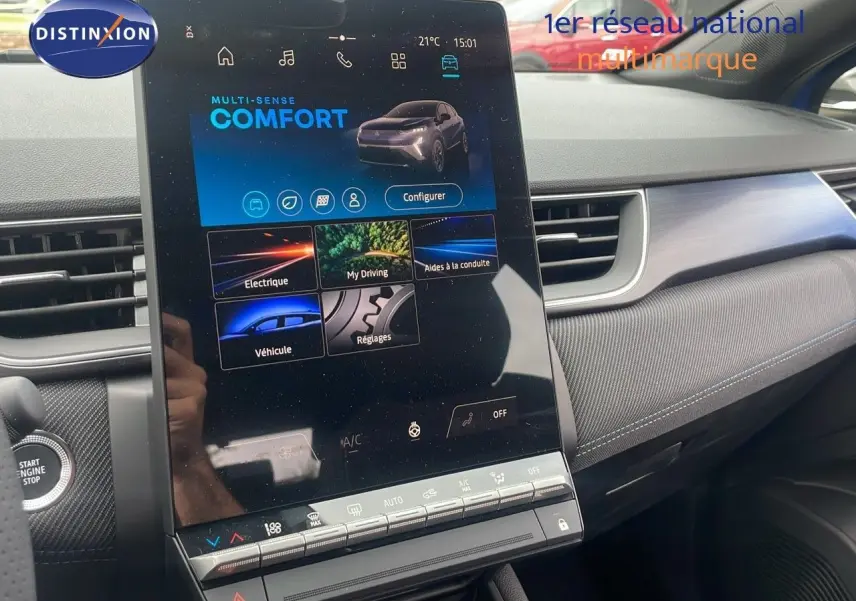 Vue rapprochée de l'écran tactile central du Renault Captur E-Tech hybride 2025 avec tableau de bord gris et détails modernes.