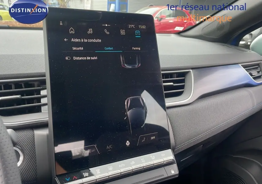 Intérieur du Renault Captur E-Tech hybride 2025, vue console centrale avec écran tactile vertical et tableau de bord gris.