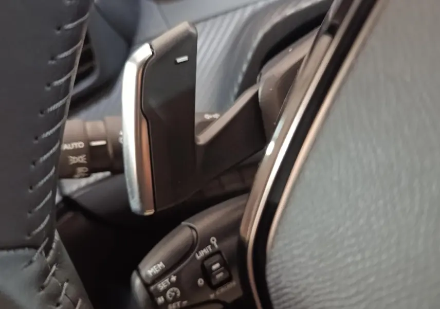 Gros plan sur le volant cuir et les commandes de régulateur de vitesse de la Peugeot 208 Hybrid gris clair.