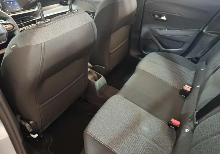 Vue intérieure arrière côté droit montrant la banquette 3 places grise et noire du Peugeot 208 Hybrid 2025.