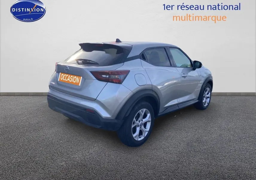 Nissan Juke gris clair vu de 3/4 arrière droit, avec jantes alliage et toit noir contrasté.
