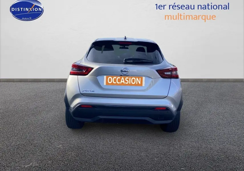 Vue arrière d'un Nissan Juke gris clair 2021 avec feux LED et logo Nissan bien visibles sur fond neutre.
