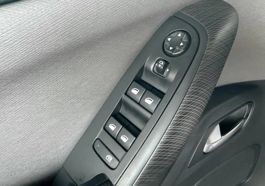 Gros plan sur les commandes de lève-vitres et rétroviseurs sur la porte côté gauche d’une Citroën C4 Picasso.