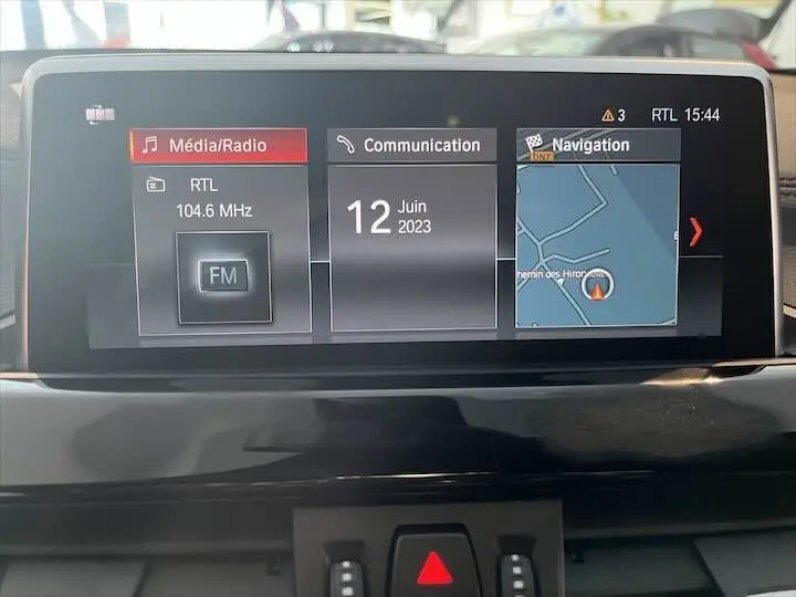 Écran central de BMW X2 2022 affichant radio FM, communication et navigation avec carte détaillée en intérieur noir.