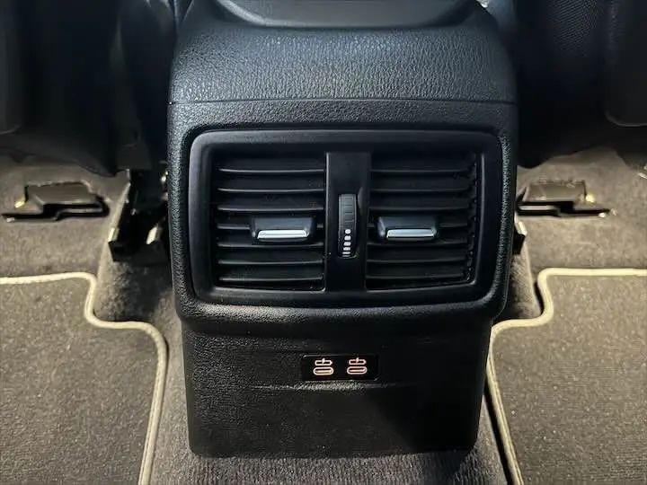 Gros plan sur la console arrière noire du BMW X2 2022 avec aérateurs et ports USB visibles au centre.