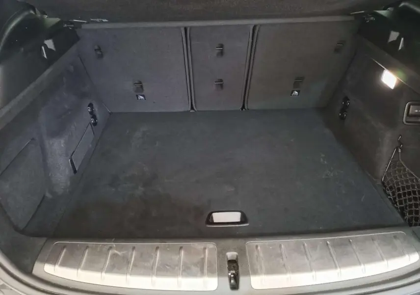Coffre spacieux en tissu noir du BMW X2 sDrive 18i 2022, vue intérieure depuis l'arrière avec seuil métallique.