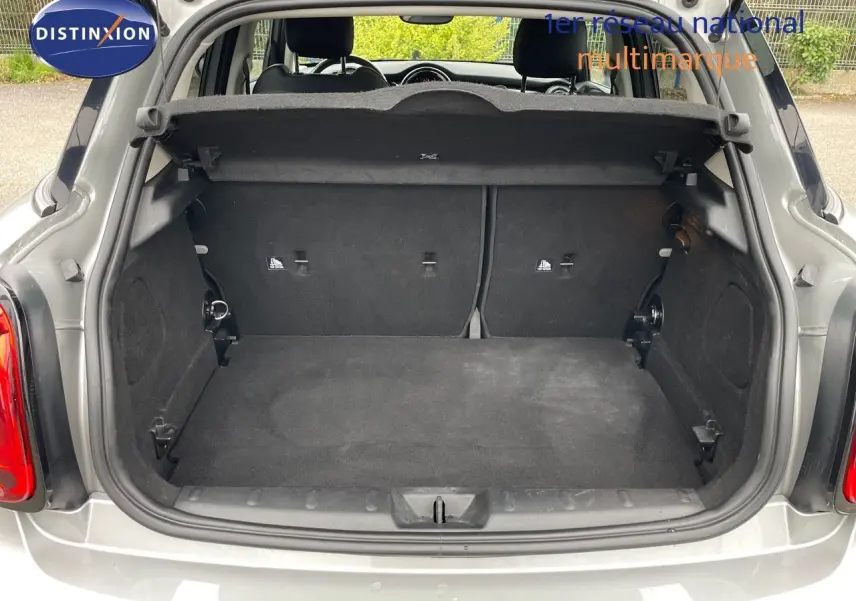 Coffre ouvert d'une MINI 1.5 136CH STEPTRONIC 2023 en Melting Silver Metal, vue arrière montrant l'espace de chargement vide.