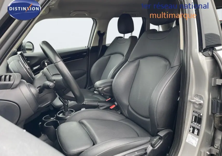 Intérieur de la MINI 2023 en Melting Silver, vue côté gauche sur les sièges avant en cuir noir et tableau de bord.