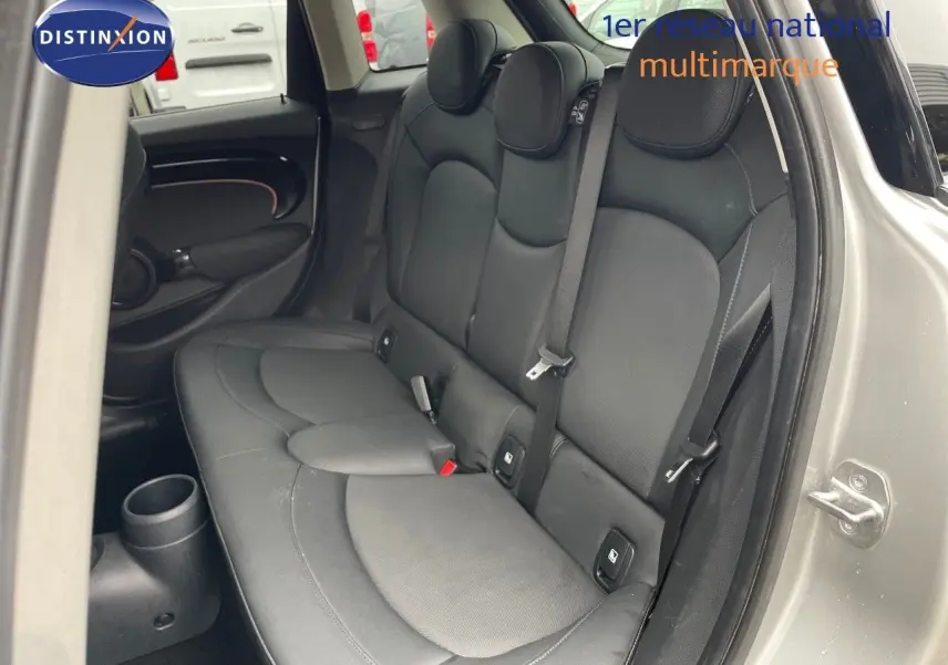 Vue côté droit de l'arrière d'une MINI 2023 Melting Silver avec banquette cuir noir et ceintures visibles.