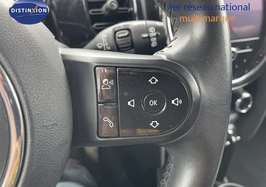 Gros plan sur les commandes du volant d'une MINI 1.5 136CH STEPTRONIC 2023 en cuir noir, intérieur moderne.