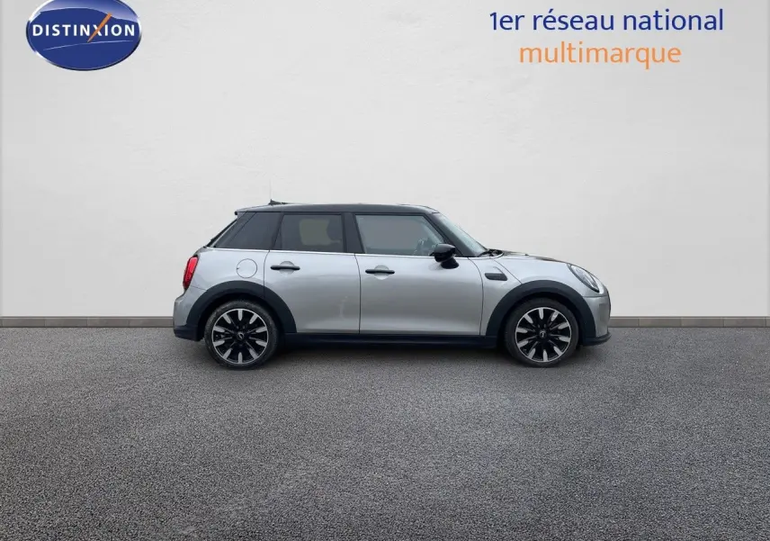 Profil droit d'une MINI 1.5 136CH STEPTRONIC 2023 en Melting Silver Metal avec toit noir et jantes bi-ton.