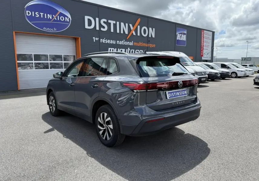 Volkswagen Tiguan 1.5 eHybrid gris dauphin vu 3/4 arrière droit avec badge eHybrid sur hayon.