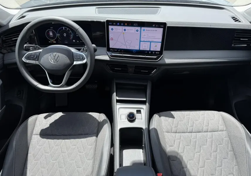 Vue intérieure frontale du Volkswagen Tiguan 1.5 eHybrid 2024 avec tableau de bord numérique et écran tactile central.