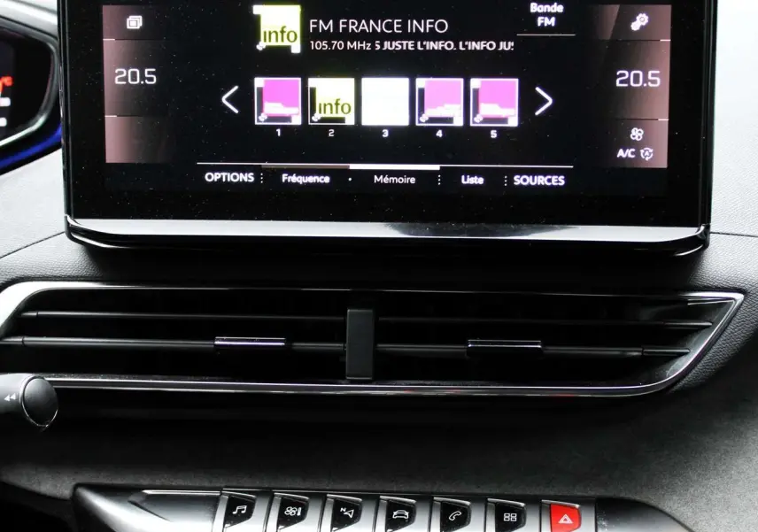 Écran tactile central affichant la radio FM dans l'habitacle noir du Peugeot 3008 blanc nacré 2025.