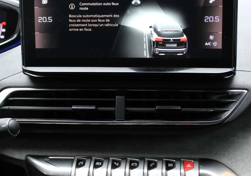 Écran central du tableau de bord du Peugeot 3008 2025 montrant l'activation automatique des feux de route