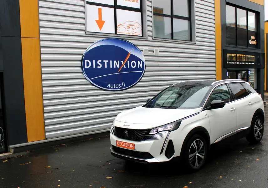 Peugeot 3008 blanc nacré en 3/4 avant droit avec toit panoramique ouvrant, stationné devant un bâtiment commercial.