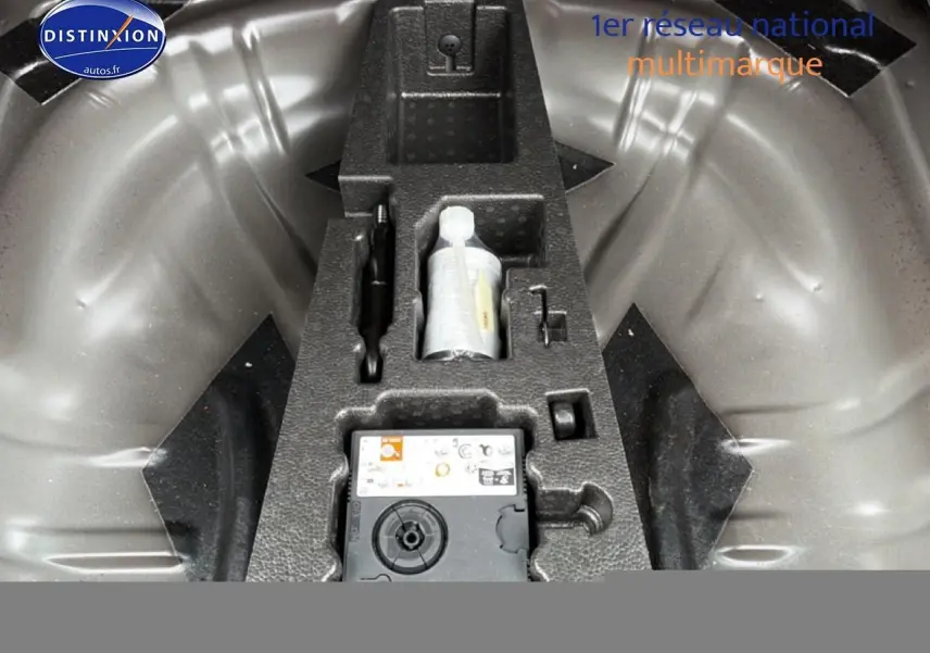 Gros plan sur le rangement sous le coffre du Skoda Karoq noir 2025 avec kit de réparation pneus intégré.