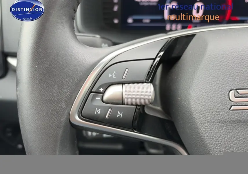 Gros plan sur les commandes audio au volant cuir noir du Skoda Karoq 1.5 TSI 2025.