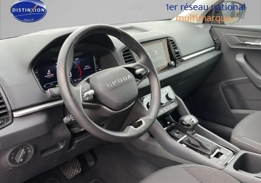 Vue intérieure avant droite du Skoda Karoq 2025, volant cuir multifonction et console centrale avec boîte auto.