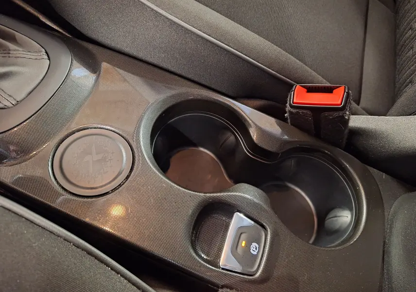 Gros plan sur la console centrale noire avec porte-gobelets et frein à main électronique du Fiat 500X 2024.