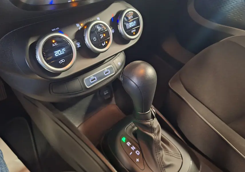 Gros plan sur la console centrale du Fiat 500X 2024 avec levier de boîte auto et commandes climatisation digitales.