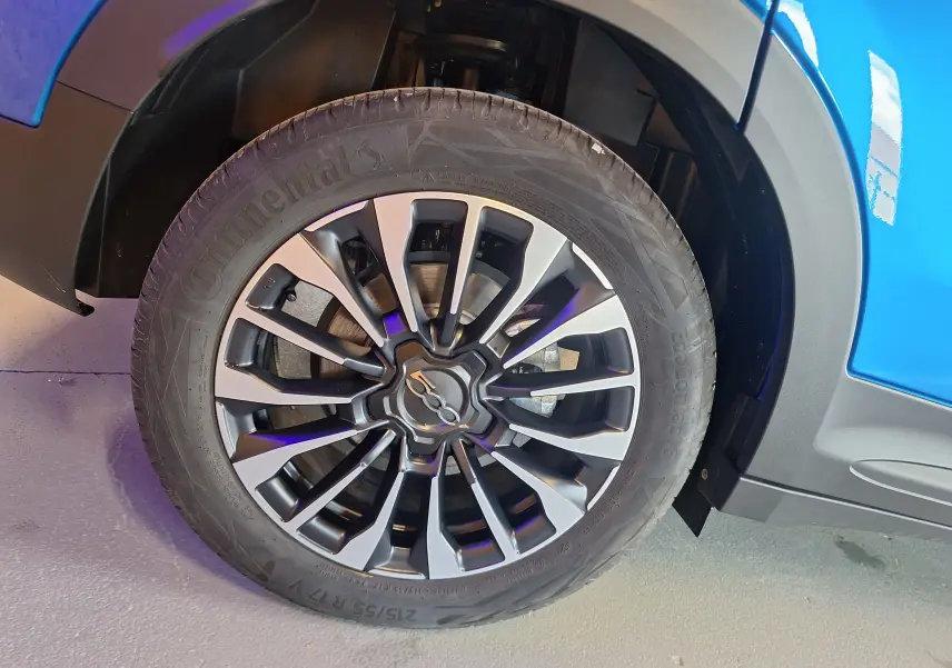 Gros plan sur la roue avant gauche d'une FIAT 500X bleu métallisé avec jante alliage au design moderne.