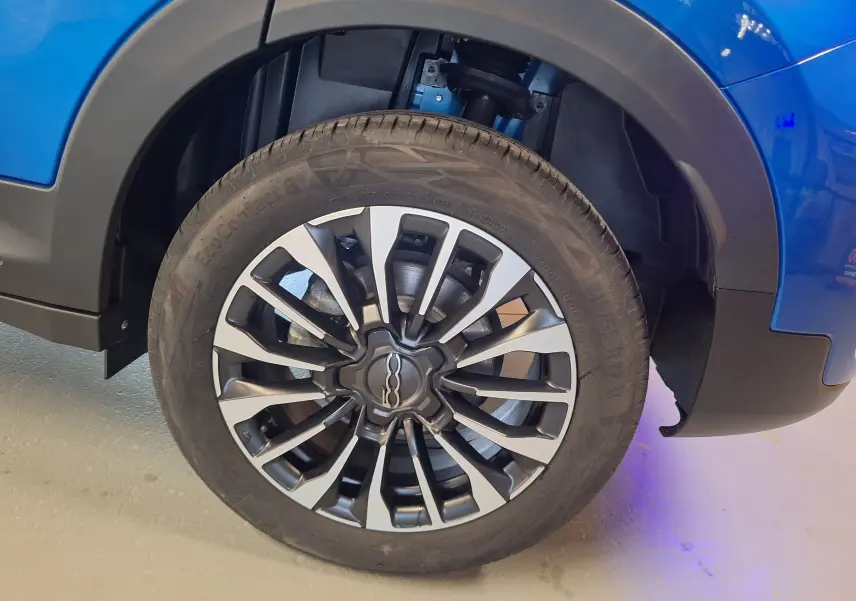Gros plan sur la roue avant droite du FIAT 500X bleu métallisé avec jante alliage au design sportif.