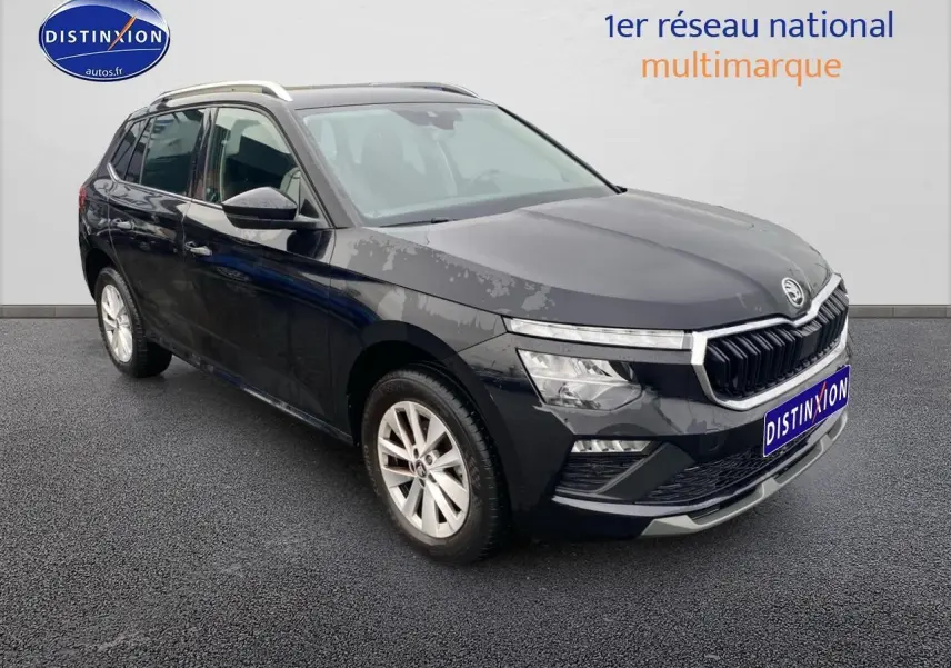 Vue 3/4 avant d'un Skoda Kamiq noir avec calandre chromée et jantes alu sur fond neutre.