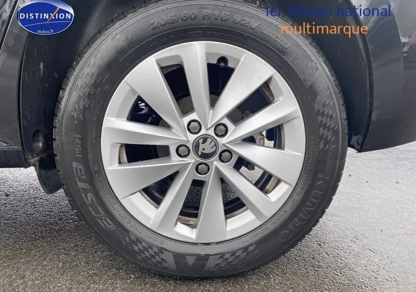 Gros plan sur la jante alu argentée et le pneu noir d'un Skoda Kamiq noir, côté gauche arrière.