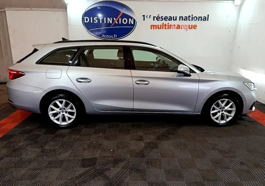 Vue latérale droite d'une SEAT Leon gris foncé break 2022 en intérieur avec jantes alliage et toit ouvrant.