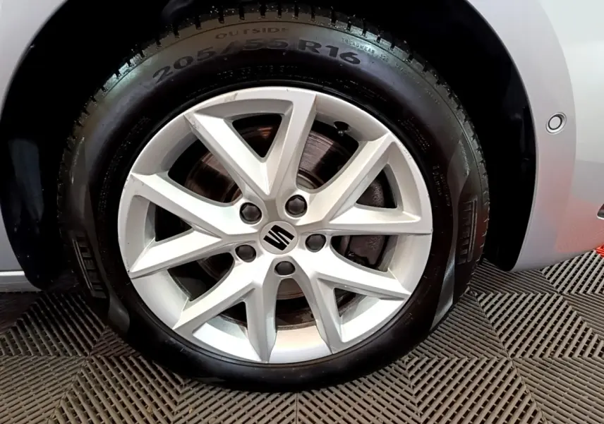 Gros plan sur la jante alliage argentée de 16 pouces avec logo SEAT sur roue avant droite d'une SEAT Leon gris foncé.
