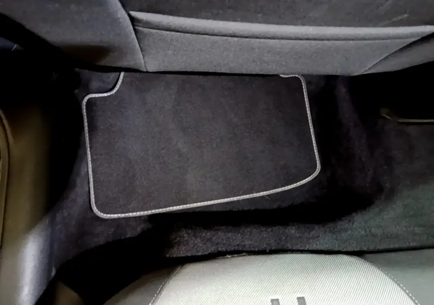 Vue rapprochée du tapis de sol noir et de la moquette sous le siège arrière d'une SEAT Leon gris foncé.