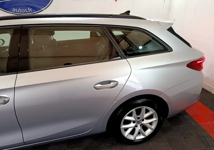 Vue latérale droite d'un break SEAT Leon gris foncé, mettant en valeur la jante alliage et la ligne de toit profilée.