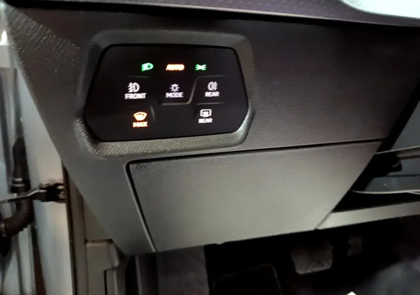 Vue intérieure côté conducteur du tableau de bord noir avec commandes d’éclairage et désembuage du SEAT Leon gris foncé.