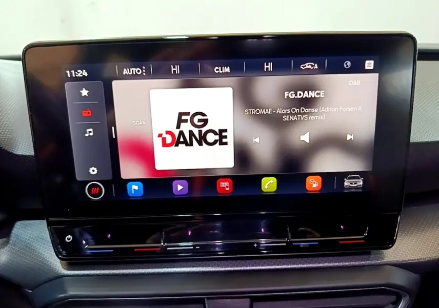 Écran tactile central du tableau de bord du SEAT Leon gris foncé, affichant une station radio FG.DANCE.