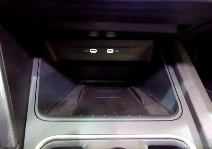 Gros plan sur la zone de recharge par induction et ports USB dans l’habitacle du SEAT Leon gris foncé 2022.