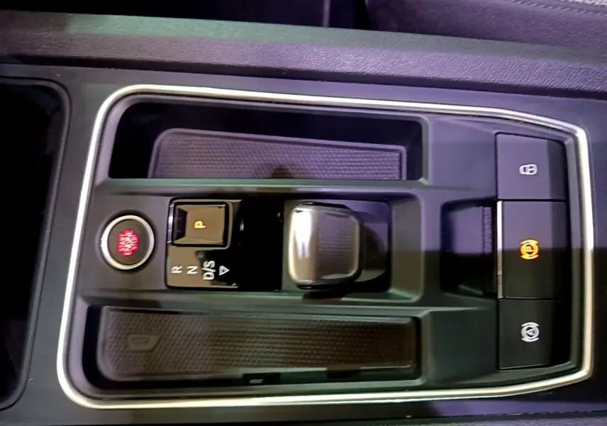 Gros plan sur la console centrale de la SEAT LEON 2022, avec bouton démarrage rouge et levier de boîte automatique.