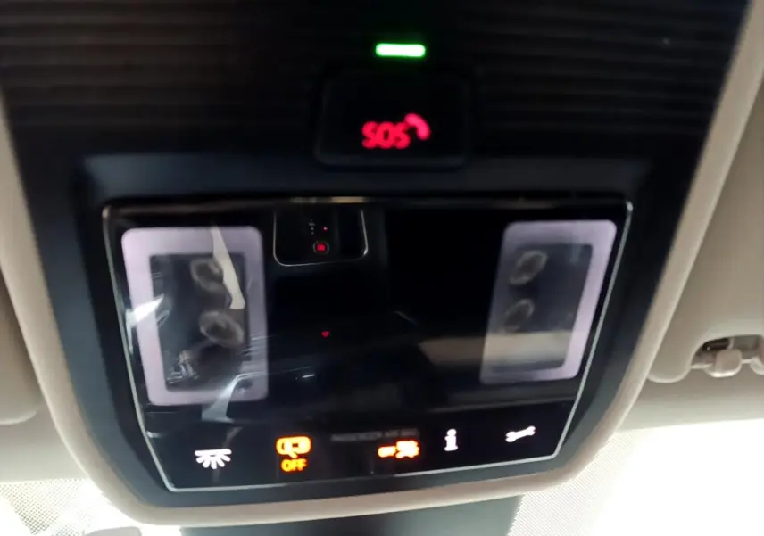 Vue intérieure du plafonnier avec éclairage d'ambiance et bouton SOS allumé dans une SEAT Leon gris foncé 2022.